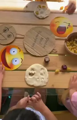 Ahşap masada oyun hamuruyla duygu yüzleri çalışması